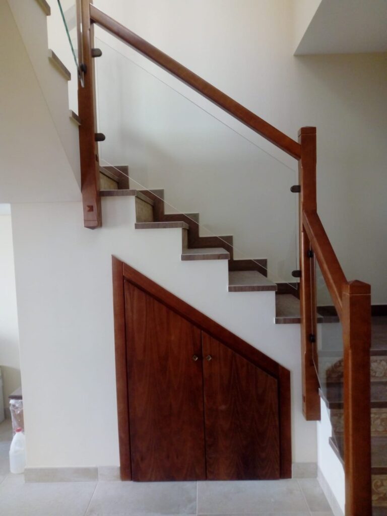 Escalera revestida de madera con pasamanos y armario bajo la escalera – Carpintería Álvaro Maqueda